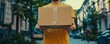 A courier holds a cardboard box in his hands