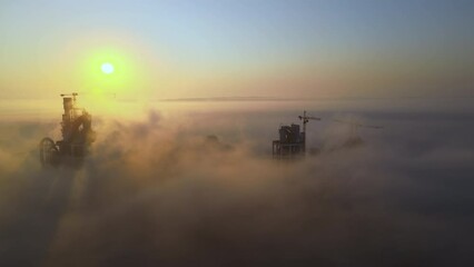 Poster - Aerial view of cement factory with high concrete plant structure and tower crane at industrial production site on foggy morning. Manufacture and global industry concept.