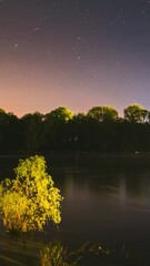 Wall Mural - Meditation By The Water. 4k Hyperlapse Meteors Fly Across The Night Sky. Night Sky Above River. From Dusk To Dawn. Stars Float Across Sky. Night Sky Turns Into Mornvertical g. Dawn Is Comvertical g