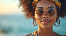 Portrait Of Female African American With Fashion Sunglasses And Orange Ethnic Headband At Beach On Summer Day