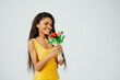 happy afro american woman in yellow dress holding flowers smiling and looking at camera  