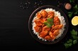 Top view of a bowl with Indian Butter chicken and basmati rice on black background providing space for text Traditional Indian dish Indian cuisine concept
