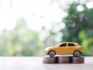 Wall Mural - Toy cars on stack of coins. The concept of saving money and manage to success transport business