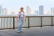 happy mature lady walk on the seaside promenade in United Arab Emirates. smiling woman walking  through city, Sharjah, UAE.