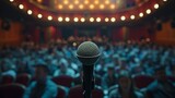 Fototapeta  - A single microphone on a stand is highlighted by a spotlight against a blurred background of an auditorium filled with an expectant audience, suggesting a live performance or speech.