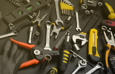 Wall Mural - Handyman tool kit on black wooden table. Many wrenches and screwdrivers, pilers and other tools for any types of repair or construction works. Repairman tools set