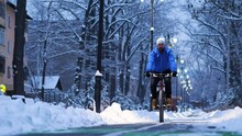 A Man Rides A Bicycle In The Winter City Late At Night. Ecological Transport. Slow Motion 2x