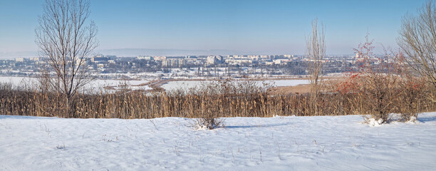 Wall Mural - Panoramic view to Ungheni city in Moldova. Beautiful winter scene with frozen Delia lake and the town covered with snow as seen from up a hill