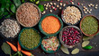 Top view of various bowls of legumes of various types and colors on a dark wooden kitchen table. Healthy food concept and detox or vegan menu. World Pulses Day.