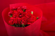 赤い背景の赤いカーネーションの花束のアップ
