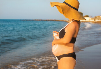 Wall Mural - Young pregnant woman on the summer beach