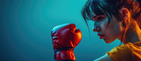 Wall Mural - Studio shot of a girl delivering a left jab in kickboxing.