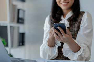 Wall Mural - An entrepreneur is talking on the phone with a company customer, Beautiful woman in the office, happy, businesswoman checks email on smartphone, manager uses mobile phone,