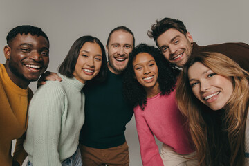 Joyful young people bonding and smiling while making selfie on beige background together