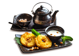 Wall Mural - Asian sweets and tea. Fried pineapple slices in batter, coconut milk sauce, ceramic teapot and a bowl with cane sugar. Isolate on a white background