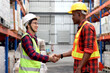 © Stella - Happy Asian senior supervisor wearing safety vest and helmet, shaking hands with his colleague worker at cargo logistics warehouse. African engineer man having hand shack with elderly Asian worker.