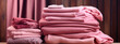 large stacks of peach colored clothes on a delicate background in designer clothing store, trendy peach