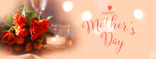 Still Life Background For Mother's Day Greetings With Red Roses And Tulips On Light Apricot Tone With Shiny Bokeh. Horizontal Background With Champagne And Candlelight. English Text.