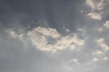 The evening sky has light shining through the clouds.