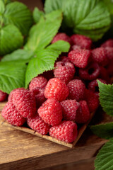 Wall Mural - Ripe juicy raspberries with leaves.