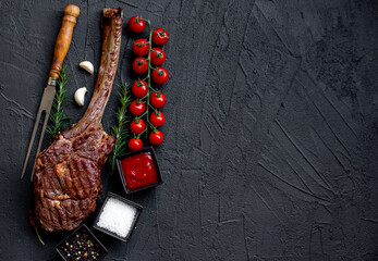 Wall Mural - Grilled Tomahawk steak on stone background with copy space for text

