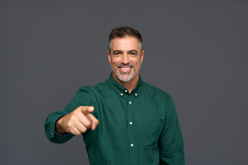 Wall Mural - Happy middle aged business man, smiling older professional businessman employer looking at camera pointing finger making choice selecting you standing isolated on gray background.