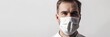young man in medical mask looking at camera isolated on grey, banner  with copy space. Medical Mask. Pandemic Concept with copy space. Healthcare Concept. Epidemic Concept.  