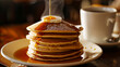 A steaming cup of coffee sits alongside a stack of pancakes drizzled with syrup. Ai Generative
