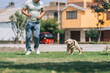 Man running next to small puppy dog on a park