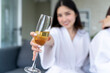 © pixs4u - Young lady in white robe holding up wineglass indoors, concept image for event