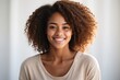 Mujer joven, afroamericana, de sonrisa perfecta, sobre fondo blanco