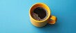 © 2rogan - Coffee in a yellow cup against a blue backdrop