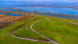 Aerial view of Sunnyvale Bay Trail on top of former landfill. Scenic view of San Francisco Bay with levees, salt marshes and sloughs.