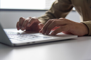 Wall Mural - Close-up hands typing on a laptop keyboard, digital work life digital flow of information in the modern professional working on a project or communication. Social network internet online