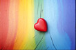 A red love heart on a rainbow wood background