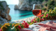 Close-up of rosé wine glass on a beach towel, with a blurred background of a beach scene, copy space