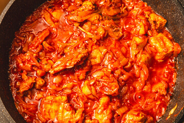 Poster - Chicken meat is stewed in tomato in a frying pan