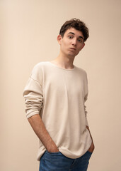 portrait of a young man in a light pullover posing for the camera, different emotions, on a light background