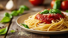  A Plate Of Spaghetti With Sauce, Basil, And Parmesan Cheese On A Wooden Table With Tomatoes And Basil On The Side Of The Plate, And Basil Leaves On The Edge Of The Plate.