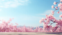 A Serene View Of Pink Cherry Blossoms Extending Over A Wooden Deck With A Clear Blue Sky In The Background.