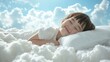 A beautiful Asian kid with a smile sleeps on a bed with a soft white blanket and pillows that look like clouds on a soft blue background.
