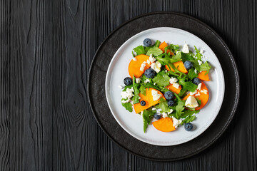 Canvas Print - arugula persimmon cheese berries salad, top view