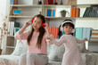 Asian child having fun and dancing with her mother in a room, active leisure and lifestyle concept