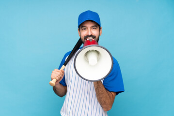 Wall Mural - Young man playing baseball over isolated blue background shouting through a megaphone