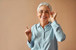 Beautiful retired woman holding glasses and looking at camera. Selection of eyeglass frames, vision test.