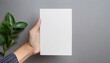 hand holding a5 template blank paper mockup on gray background