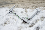 Fototapeta  - Trottinette électrique abandonnée dans la neige sur le trottoir. trottinette électrique,neige,hiver,trottoir, trottinette, électrique, trottoir, problème, urbain, ville, rue, route, machine, neige,