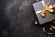 © candra - a black gift with a gold ribbon on a black background
