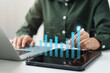 © Prae_Studio - Businesswoman analyzing company's business financial balance sheet working with digital augmented reality graphics, Businesswoman calculates financial data for long-term investment.