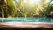 © pjdesign - empty wooden table top and blurred swimming pool in tropical resort with blurred background